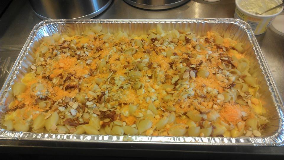 A large casserole topped with cheese and almond slivers.