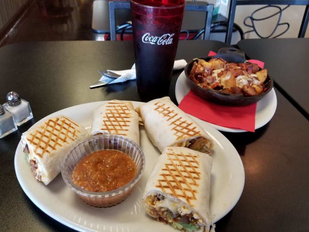 A plate of grilled gorditas with sauce for dipping.